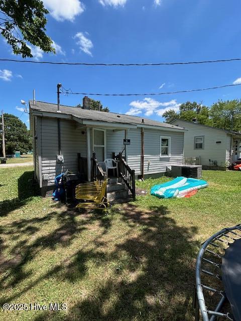 rear view of property with a yard