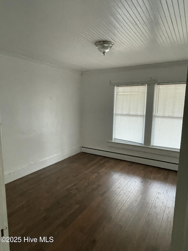 spare room with dark wood finished floors, baseboards, and baseboard heating