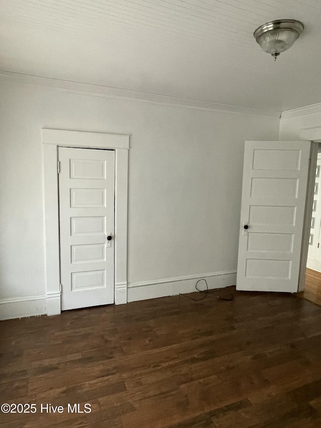 unfurnished room with baseboards, wood finished floors, and crown molding