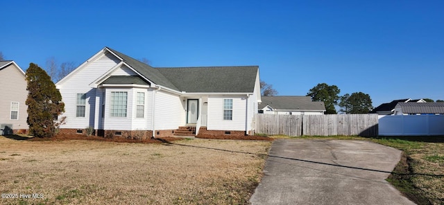 view of front of home with crawl space, entry steps, a front yard, and fence