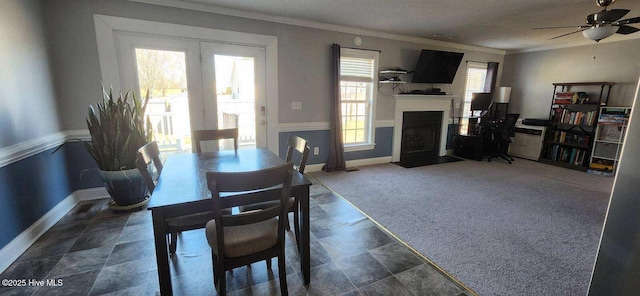 dining area featuring baseboards, a fireplace with flush hearth, carpet flooring, and crown molding