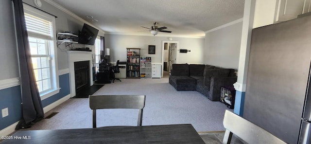 living room featuring a fireplace with flush hearth, carpet, visible vents, and a textured ceiling