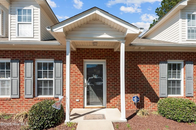 property entrance featuring brick siding