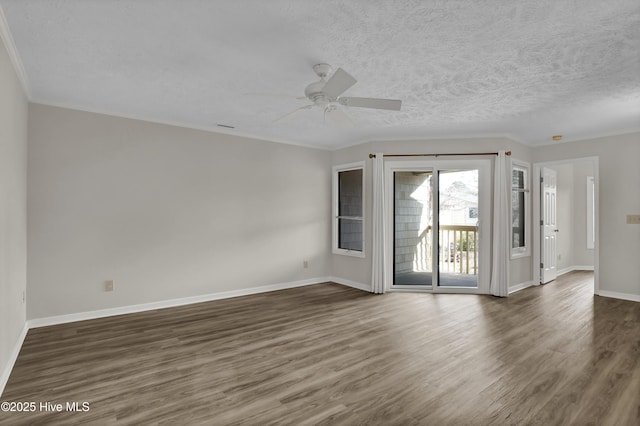 spare room featuring dark wood-type flooring, ornamental molding, a textured ceiling, baseboards, and ceiling fan