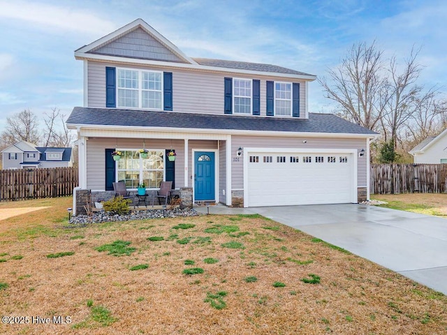 view of front of house with a front yard, fence, covered porch, concrete driveway, and stone siding