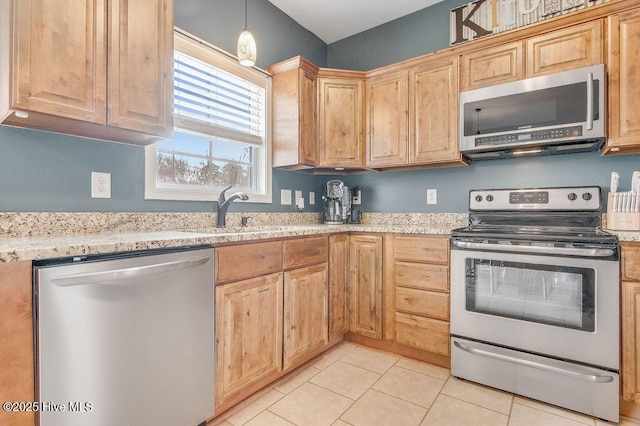 kitchen with light tile patterned flooring, light brown cabinetry, and stainless steel appliances