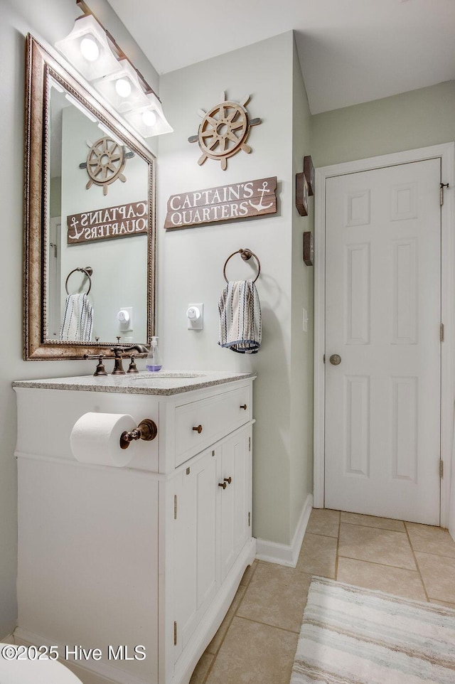 bathroom with tile patterned flooring, vanity, and baseboards