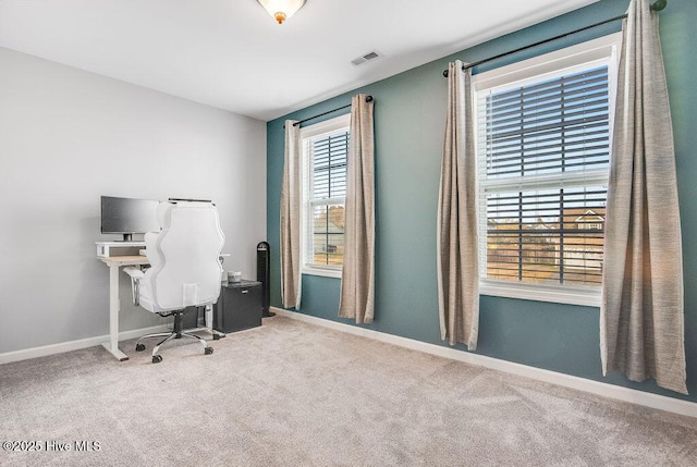 carpeted office space featuring visible vents and baseboards