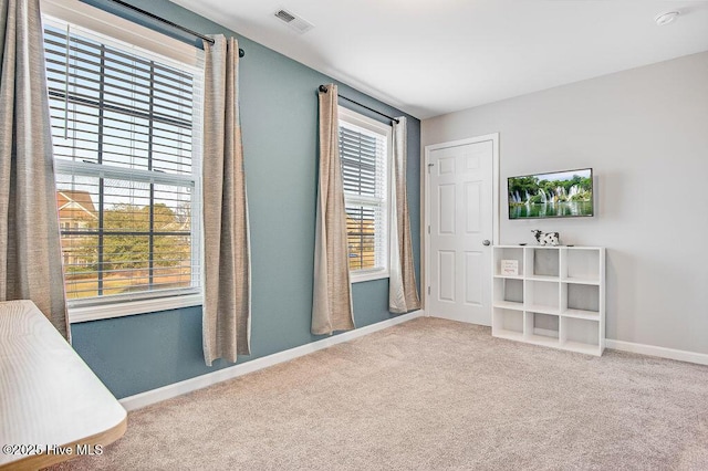 carpeted spare room with baseboards and visible vents