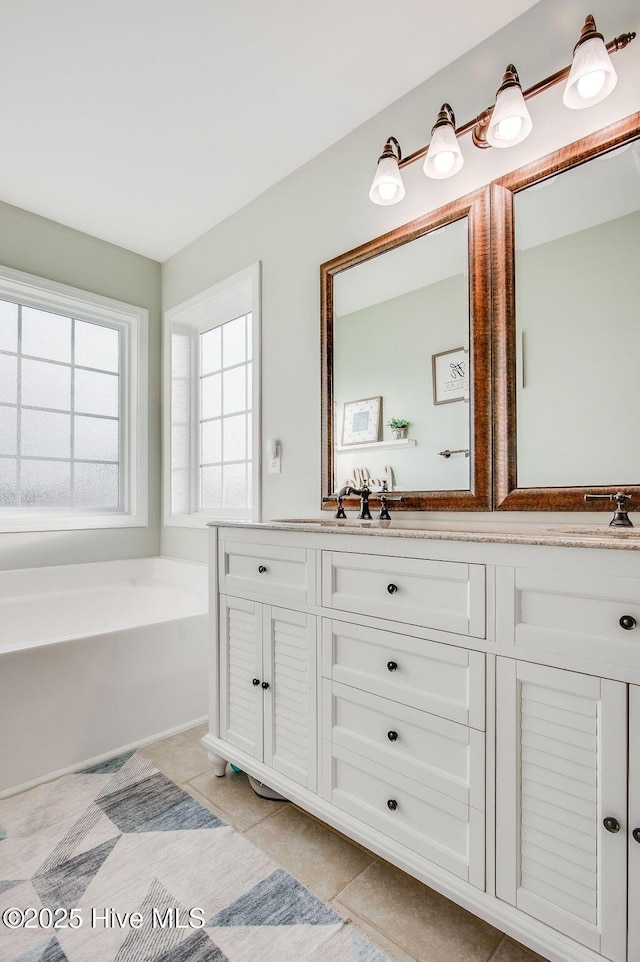 full bathroom with tile patterned floors, a bath, and vanity