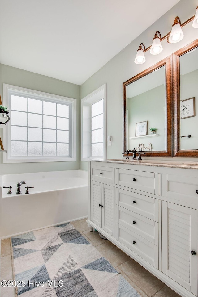 bathroom with vanity, a bath, and tile patterned flooring