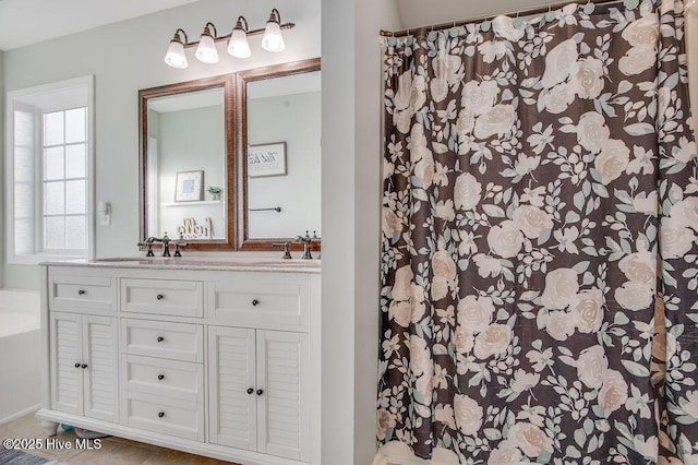 full bathroom with a sink and double vanity