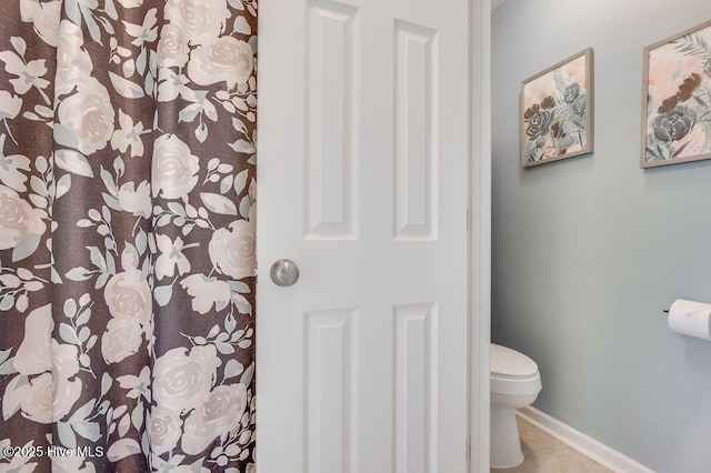 full bath featuring toilet and baseboards