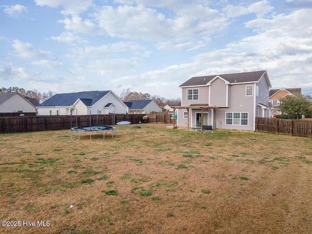 view of yard featuring a fenced backyard, a residential view, and a trampoline