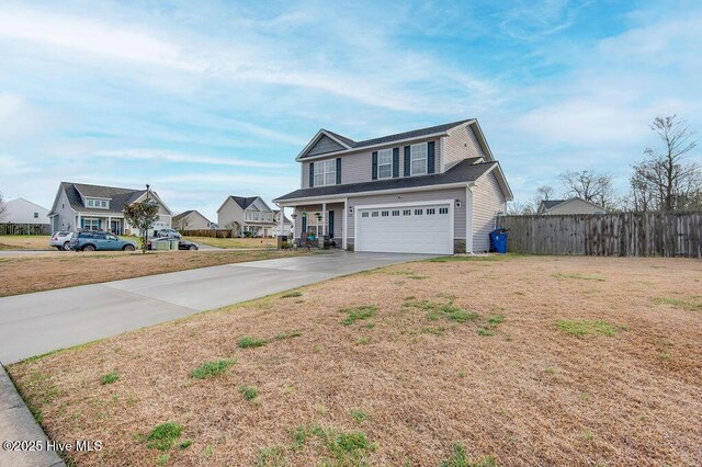 traditional-style house with fence, a residential view, concrete driveway, an attached garage, and a front yard