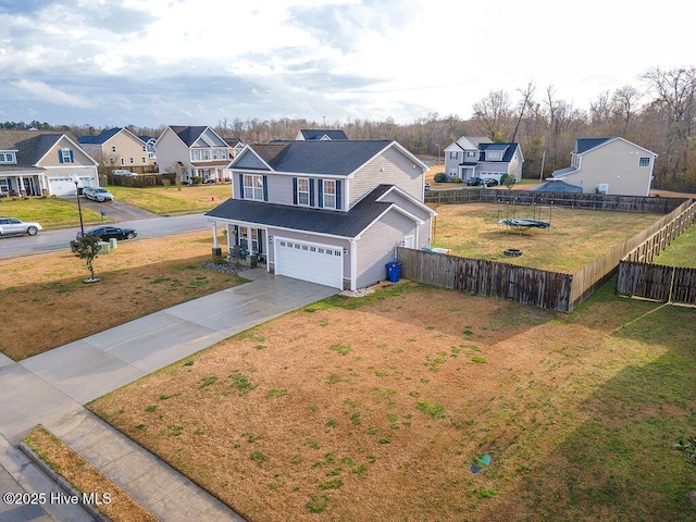 view of front facade with a residential view, concrete driveway, an attached garage, and fence