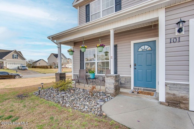 doorway to property with stone siding and covered porch