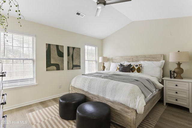 bedroom featuring a ceiling fan, wood finished floors, visible vents, baseboards, and lofted ceiling