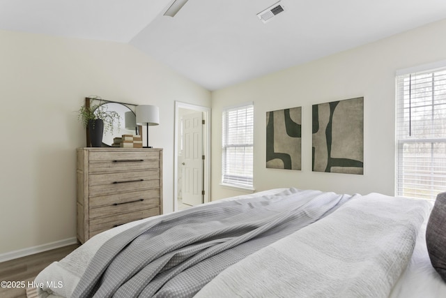 bedroom with visible vents, multiple windows, lofted ceiling, and wood finished floors