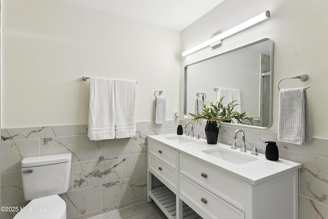 bathroom with a sink, toilet, and tile walls