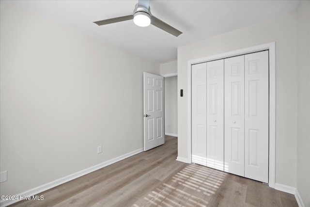 unfurnished bedroom featuring a closet, ceiling fan, baseboards, and wood finished floors