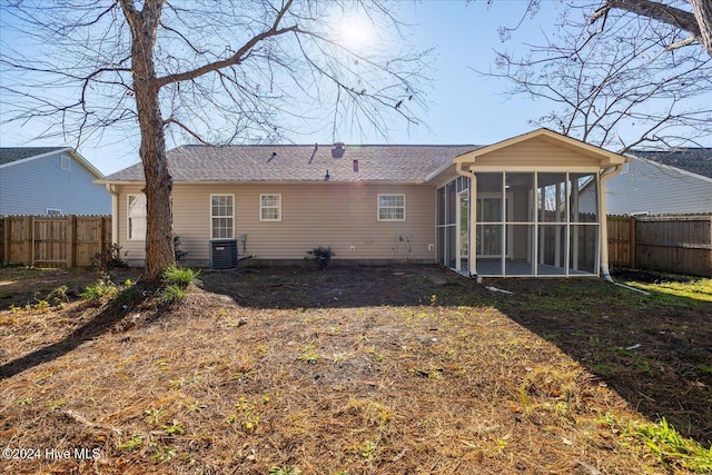 back of property featuring central air condition unit, a fenced backyard, and a sunroom