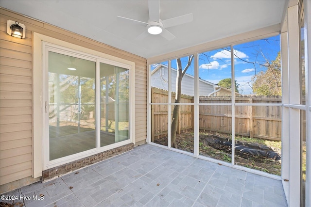 unfurnished sunroom with a ceiling fan