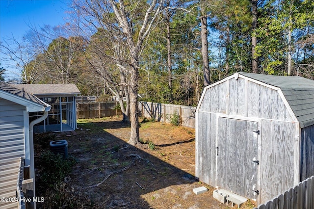 view of yard featuring central air condition unit, an outbuilding, a storage shed, and a fenced backyard