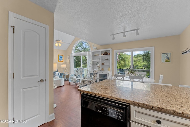 kitchen featuring a textured ceiling, black dishwasher, dark wood finished floors, and vaulted ceiling