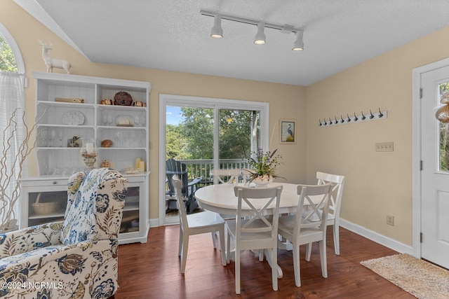 dining space with baseboards, a textured ceiling, and wood finished floors