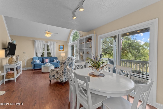 dining space with baseboards, vaulted ceiling, wood finished floors, a textured ceiling, and a ceiling fan