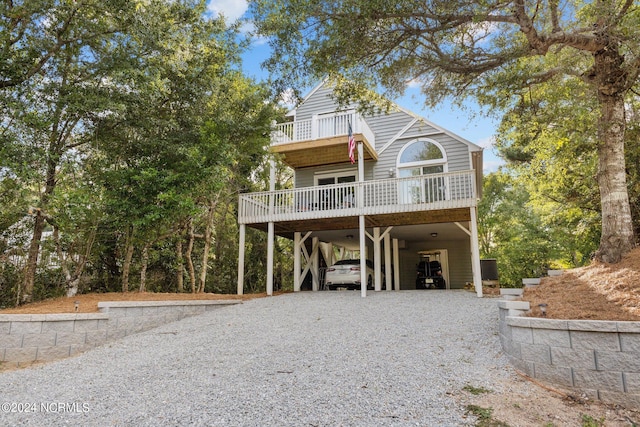 view of front facade with a carport, gravel driveway, and a balcony