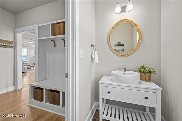 bathroom featuring vanity, wood finished floors, and baseboards