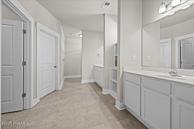 full bath with vanity, baseboards, and visible vents