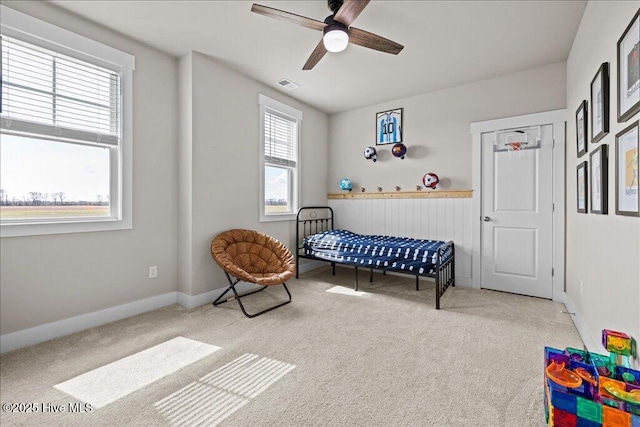 carpeted bedroom featuring a ceiling fan, baseboards, and visible vents