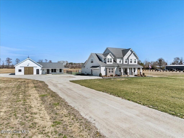 shingle-style home featuring a front lawn and dirt driveway