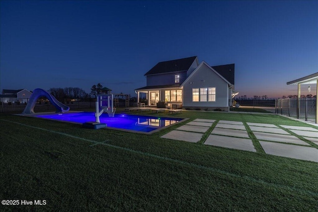 rear view of property with a fenced in pool, playground community, a yard, a fenced backyard, and a patio area