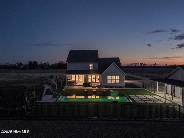 back of property featuring a fenced in pool, a yard, a fenced backyard, a playground, and a patio area