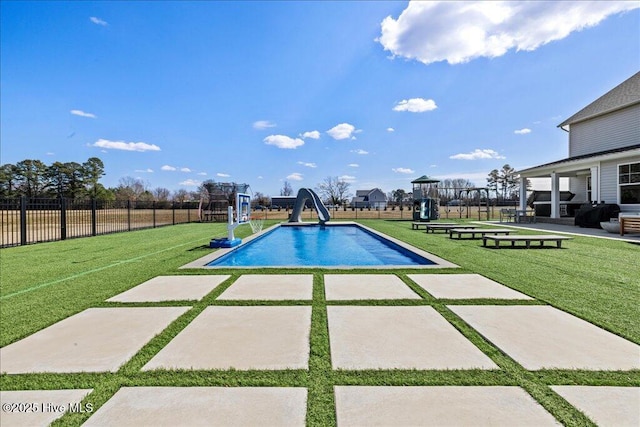 view of swimming pool featuring a fenced in pool, a water slide, fence, playground community, and a lawn