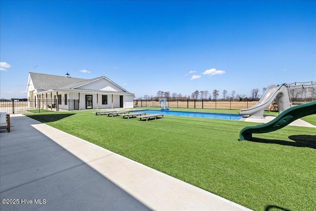 view of yard featuring a fenced in pool, playground community, and fence