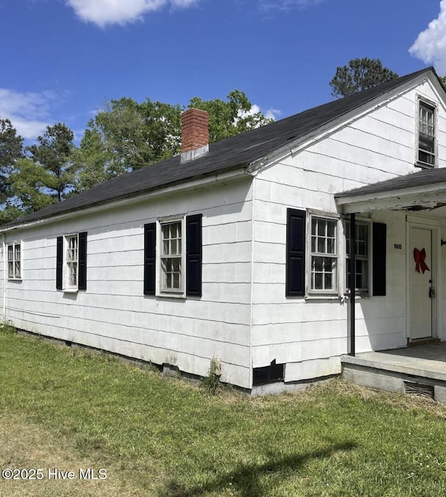 view of home's exterior with a yard and a chimney