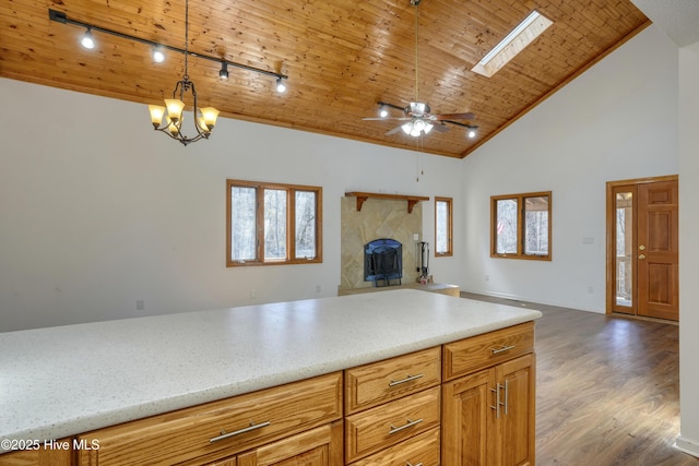 kitchen featuring high vaulted ceiling, dark wood-style floors, open floor plan, wooden ceiling, and a fireplace