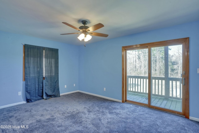 carpeted empty room with baseboards, visible vents, and ceiling fan