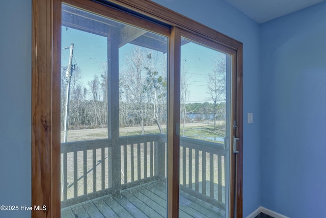 doorway to outside featuring a healthy amount of sunlight and baseboards