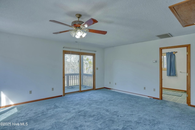 unfurnished room featuring attic access, a ceiling fan, visible vents, and carpet floors