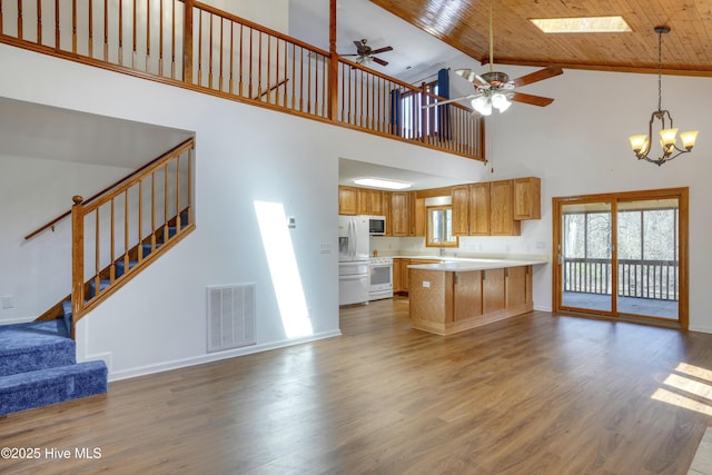 kitchen with visible vents, white appliances, open floor plan, and wood finished floors