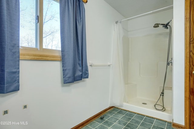 full bath featuring tile patterned flooring, a shower with shower curtain, and baseboards