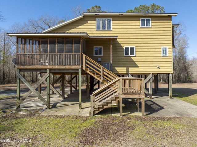 rear view of house featuring stairway, a patio, central AC, and a sunroom