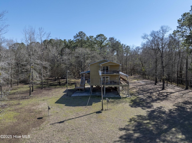 back of house with a carport, stairway, a forest view, and a wooden deck