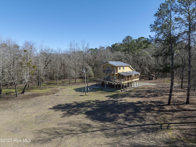 exterior space featuring a forest view and a wooden deck